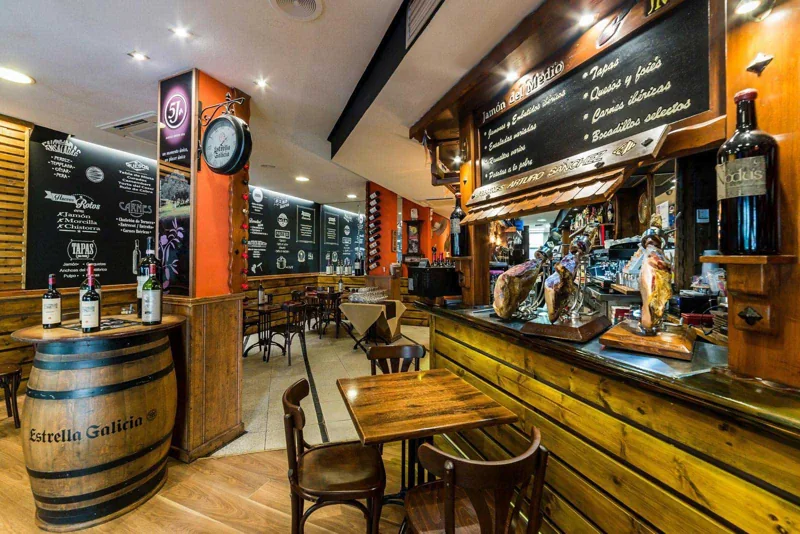 Interior de Jamón del Medio, con su barra de jamones y pizarras